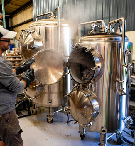a person unloading a blue myco 310L autoclave with steam coming out